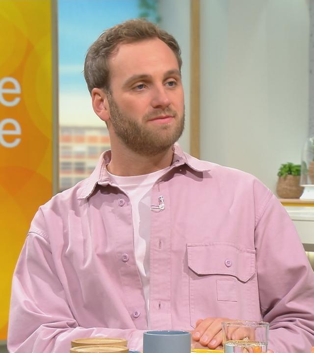 Psychologe Leon Windscheid im pinken Hemd sitzt im Volle-Kanne-Studio
