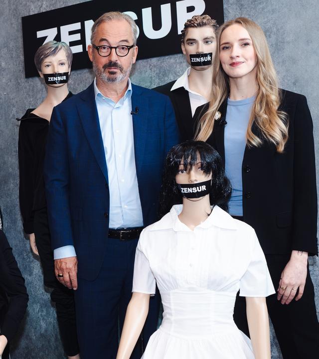 Leonie Plaar und Jan Fleischhauer sind umgeben von Schaufensterpuppen, denen je ein schwarzer Balken mit der Aufschrift "Zensur" über den Mund geklebt wurde.