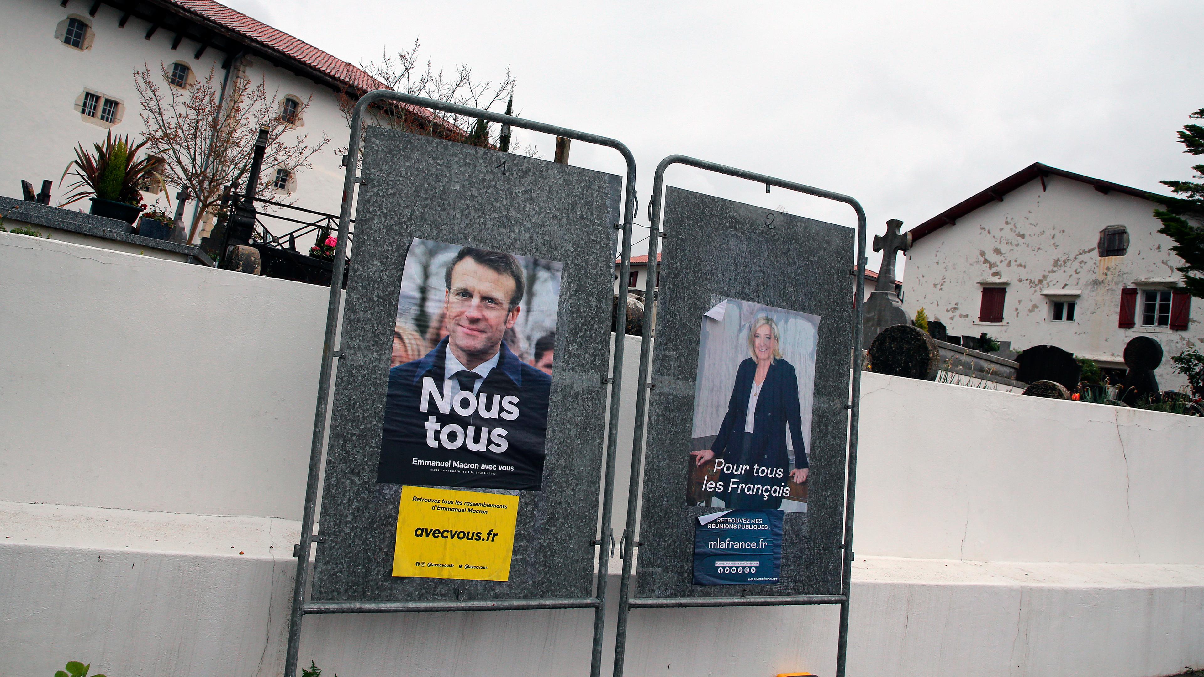 Wahlplakate von Marine Le Pen und Emmanuel Macron angeschlagen vor einer Mauer
