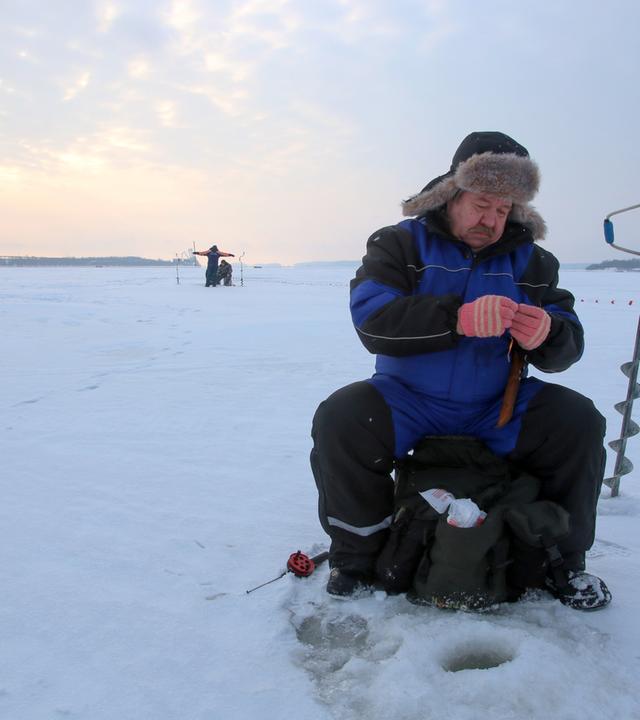 "Let it snow": Ein Mann angelt an einem Eisloch.