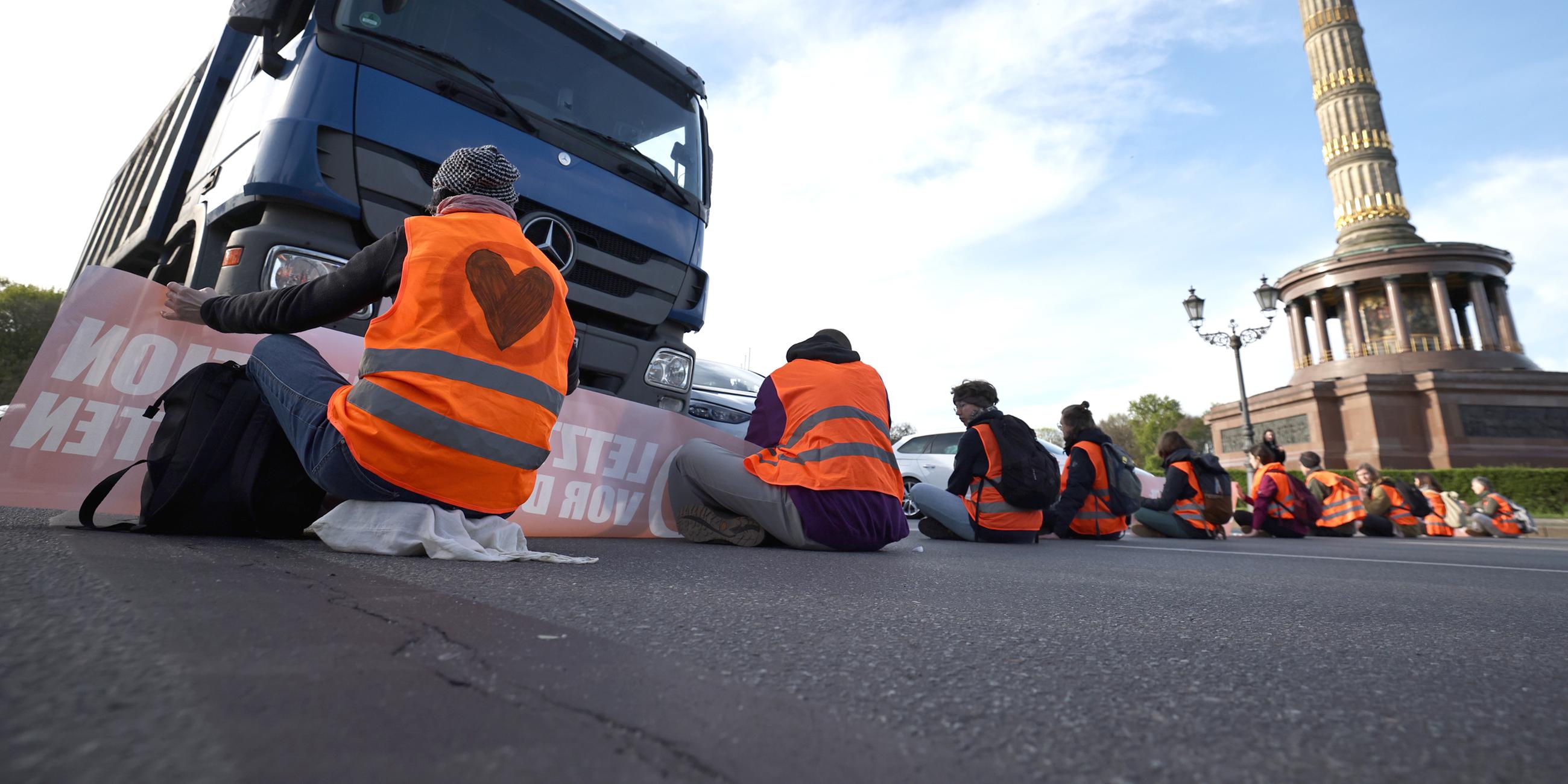 Aktivisten blockieren eine Straße während eines Klimaprotestes an der Siegessäule in Berlin