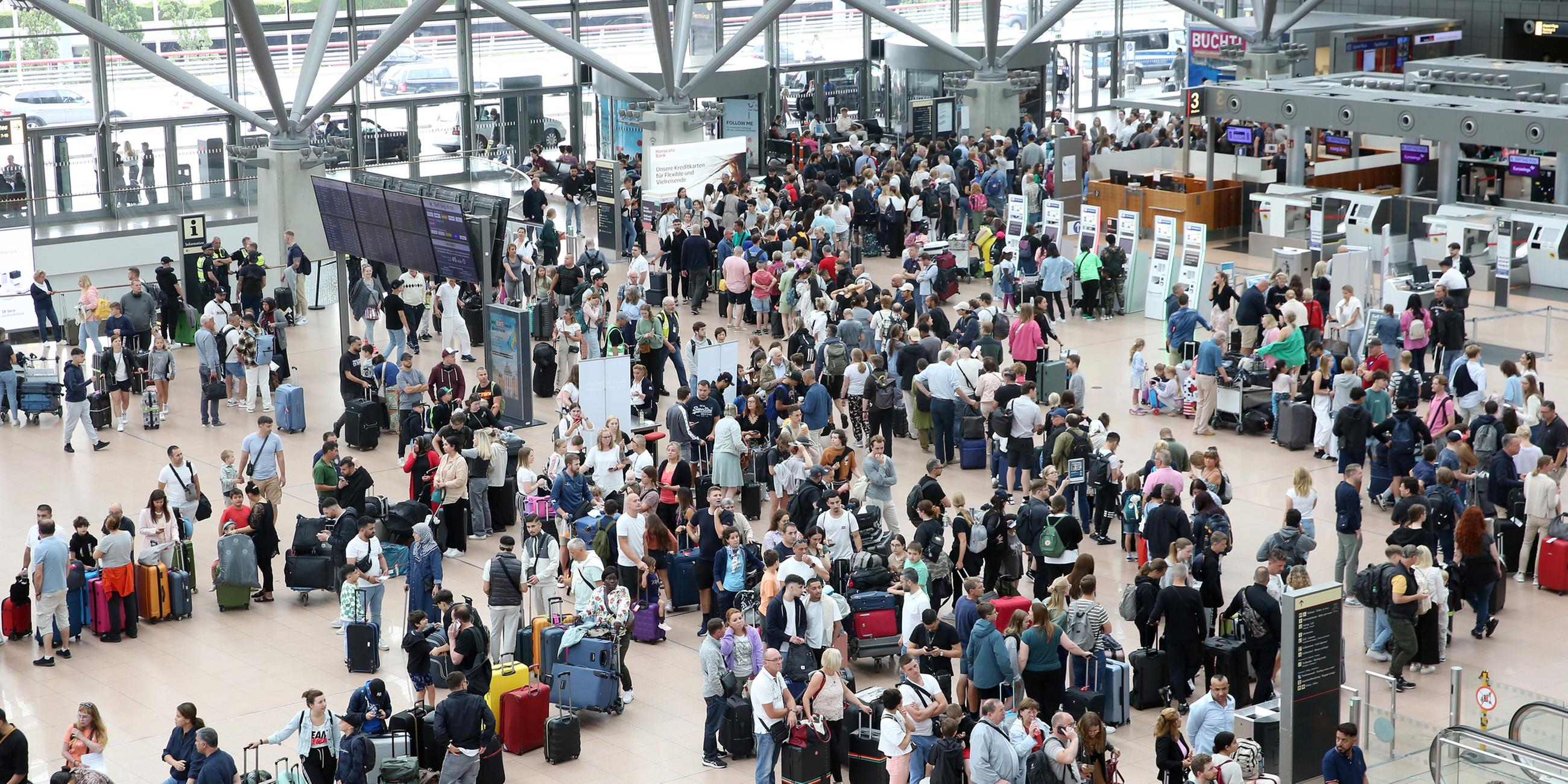 Zahlreiche Reisende warten am 13.07.2023 während einer Blockade eines Rollfeldes durch Klimaaktivisten im Terminal des Hamburger Flughafens.