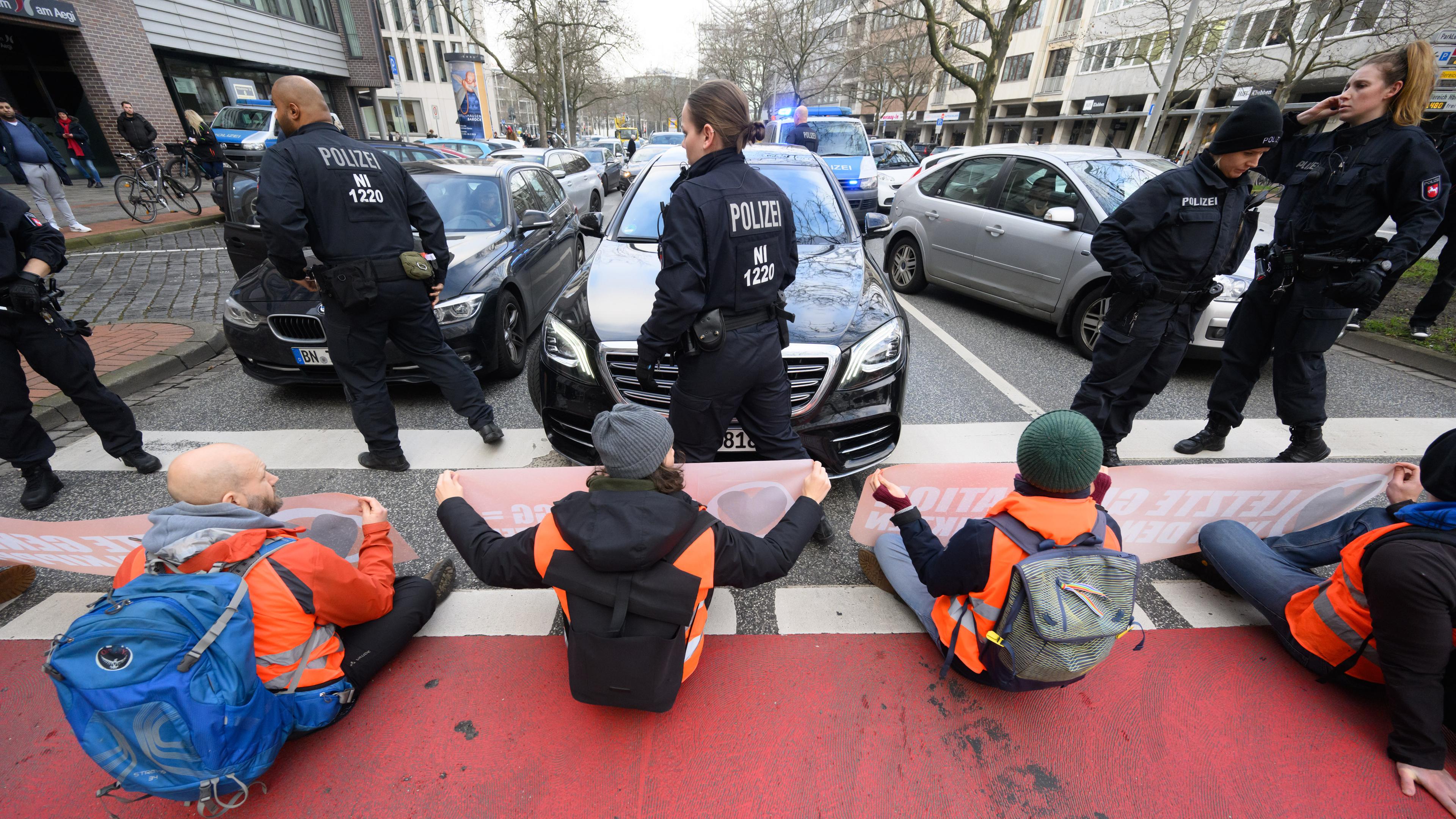 Aktivisten der Gruppierung "Letzte Generation" blockieren auf der Hildesheimer Straße in Hannover den Verkehr. 