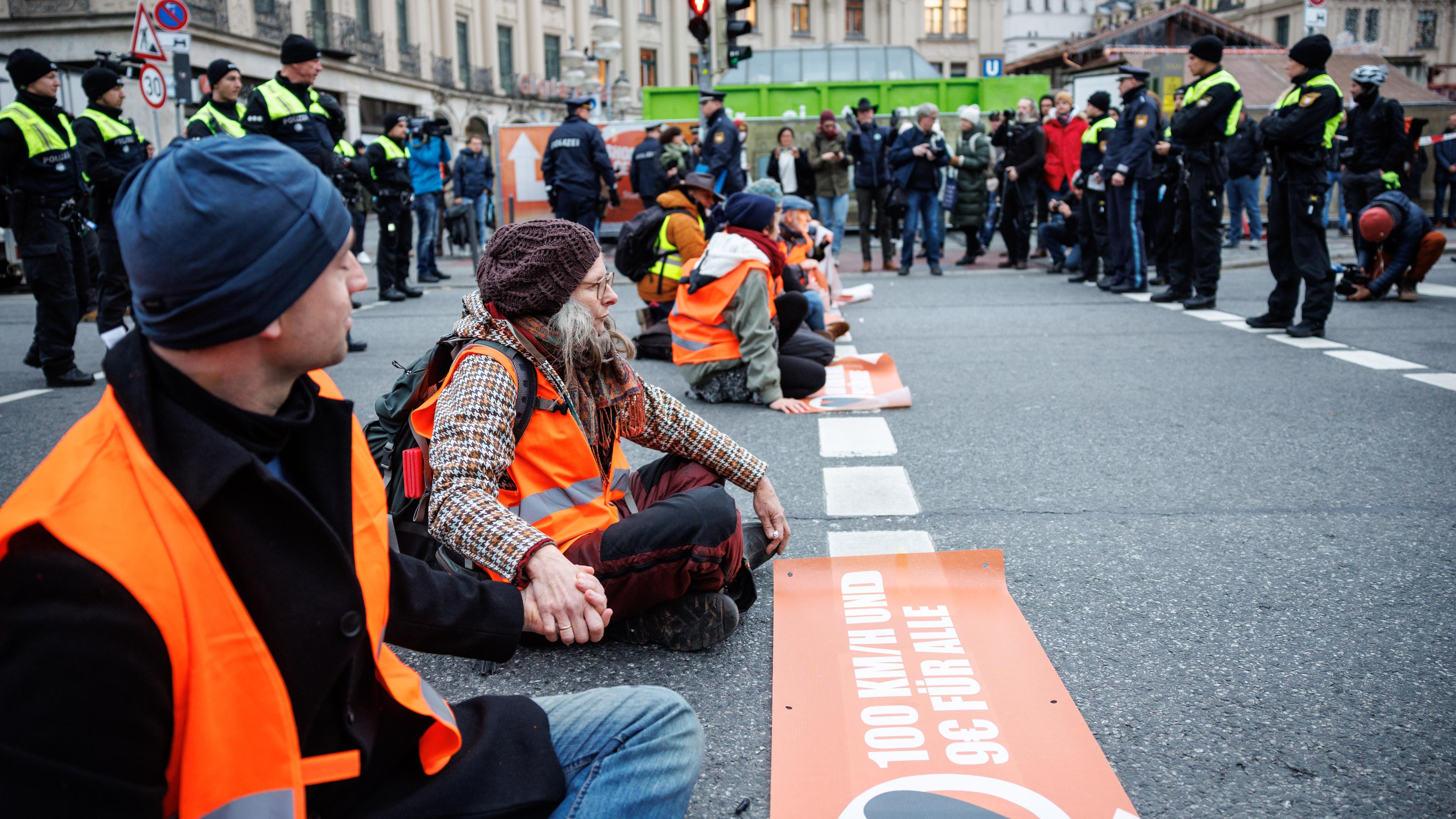 Bayern, München: Aktivisten der Klimaschutz-Initiative "Letzte Generation" haben sich am Stachus mit ihren Händen auf die Straße geklebt.