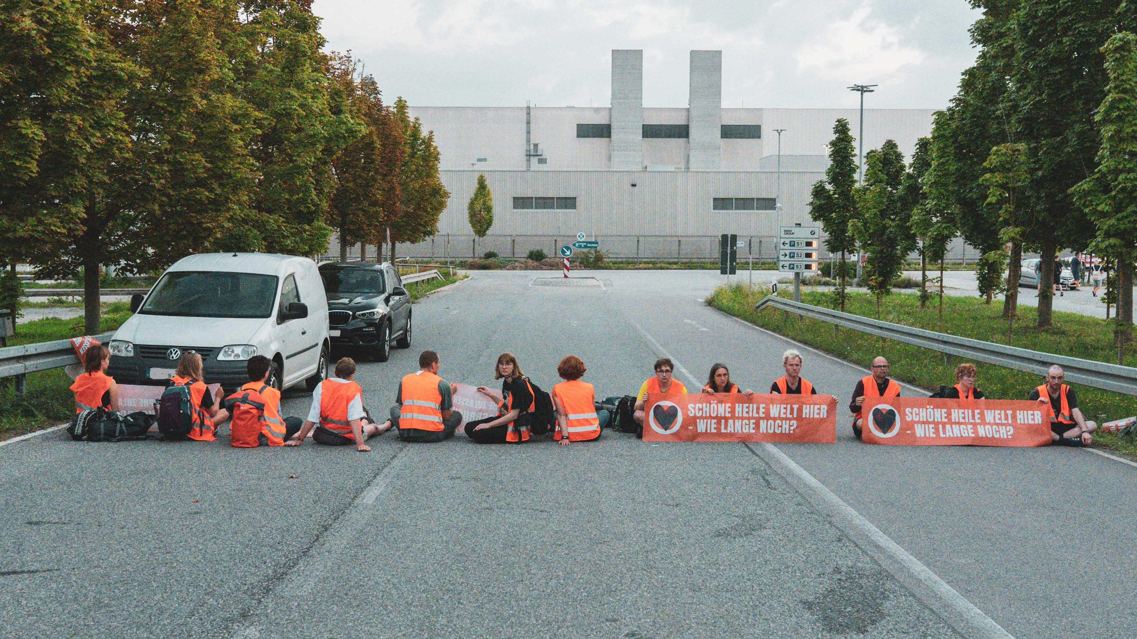 Aktivist*innen der Letzten Generation blockieren am 22.8.2023 in Regensburg die Zufahrten zum BMW-Werk.