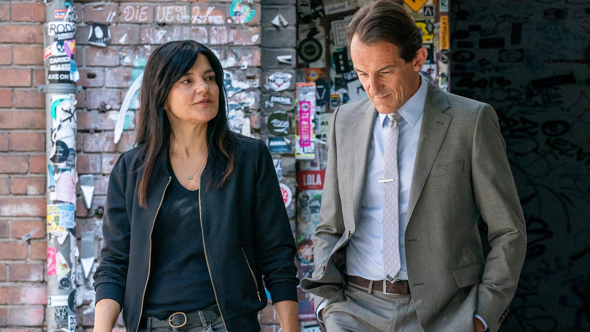 Mina Amiri (Jasmin Tabatabai, l.) und Oliver Radek (Hans-Werner Meyer, r.) laufen nebeneinander auf einem Gehweg entlang und unterhalten sich.