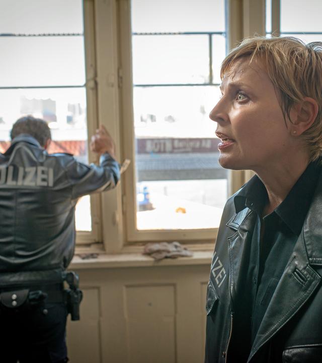 "Notruf Hafenkante - Letzter Schritt": Melanie Hansen (Sanna Englund) steht in einem Zimmer und schaut verzweifelt vor sich ins Leere. Im Hintergrund, mit dem Rücken zu ihr, steht ihr Kollege Mattes Seeler (Matthias Schloo). Er hat sich mit beiden Händen an einem Fensterrahmen abgestützt und lässt verzweifelt den Kopf hängen.