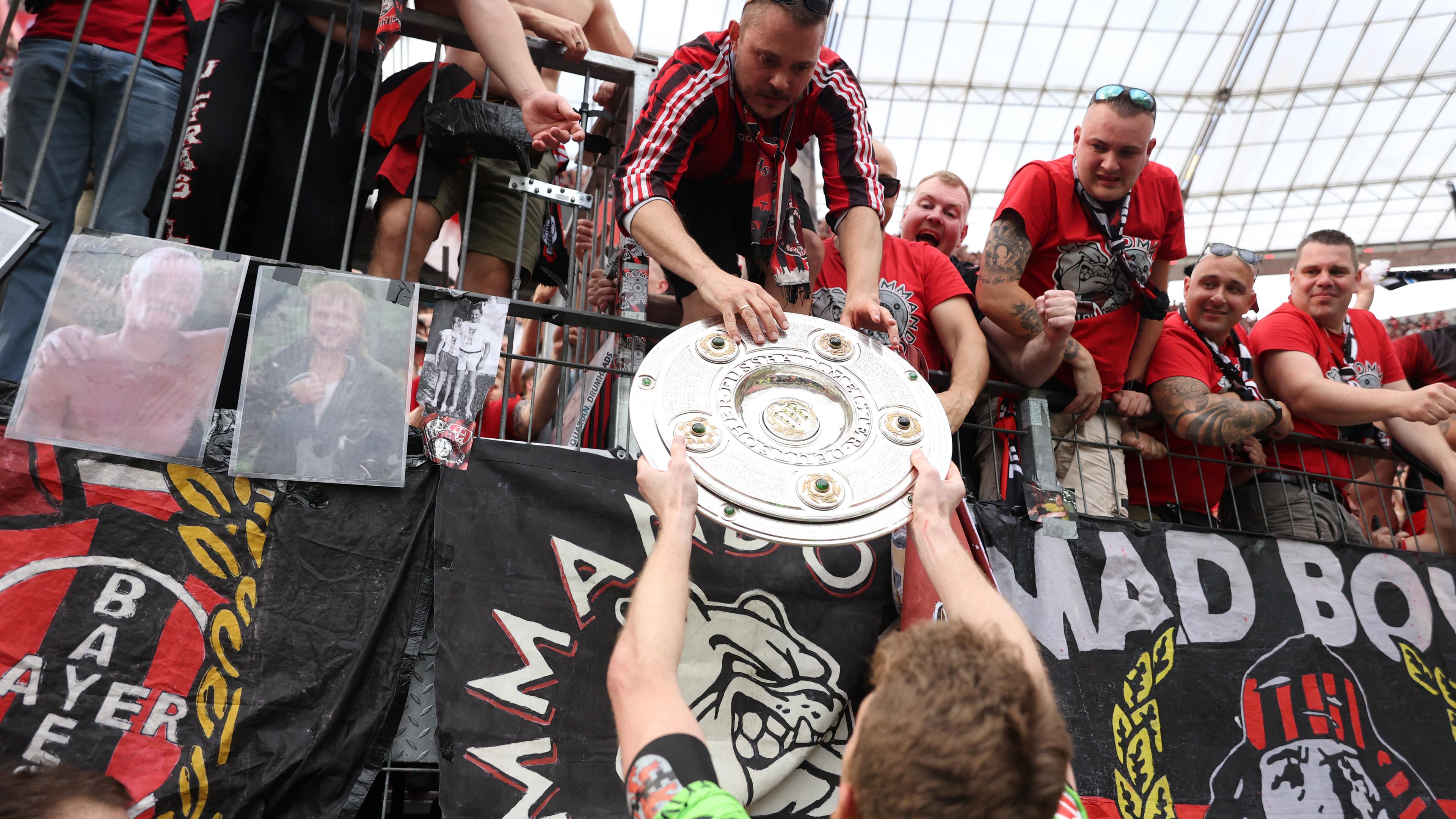 Bayer Leverkusen's Lukas Hradecky gibt die Meisterschale an Fans am 18.05.24.