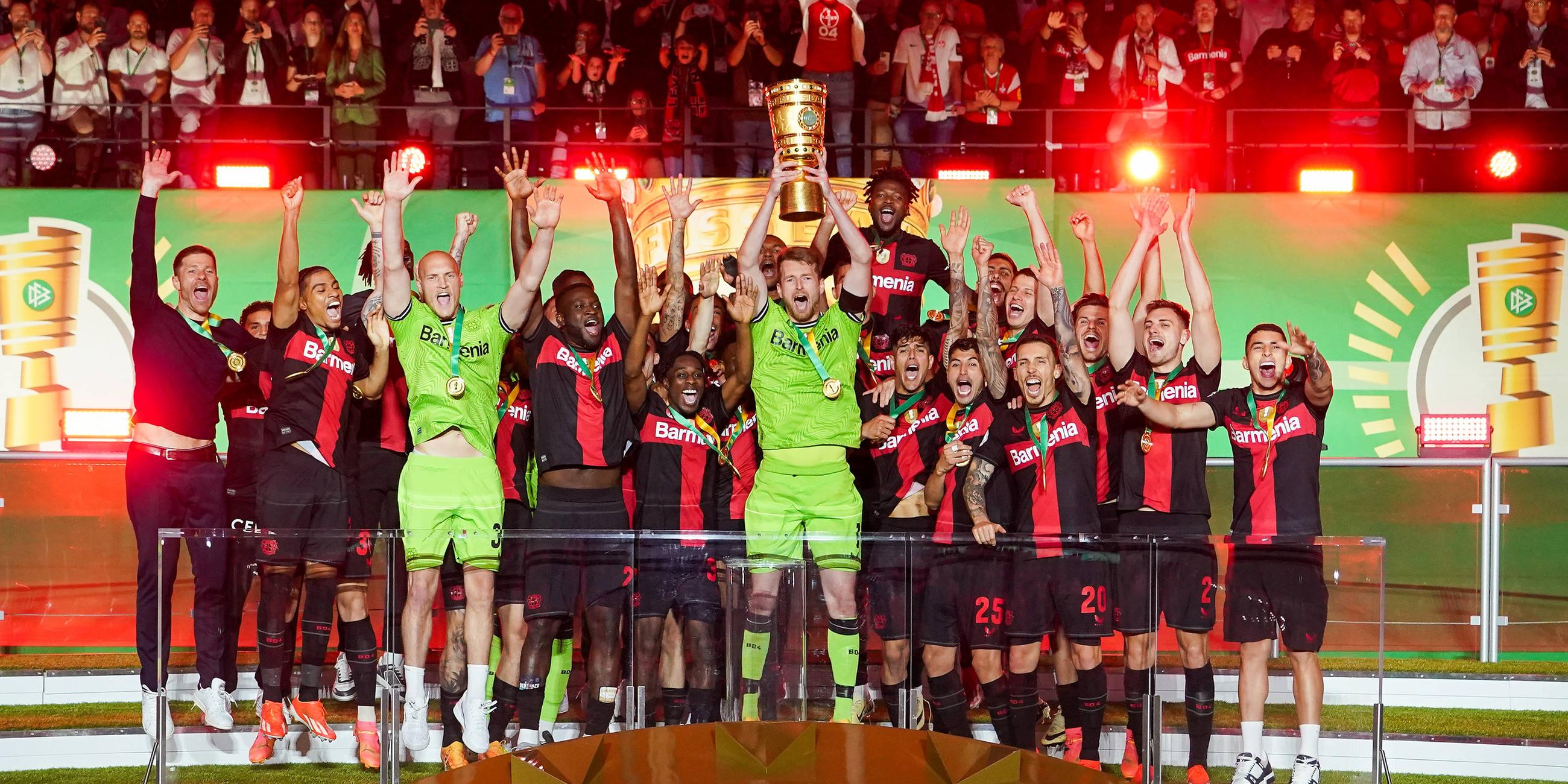 Bayer Leverkusens Spieler jubeln mit dem Pokal über das Double.