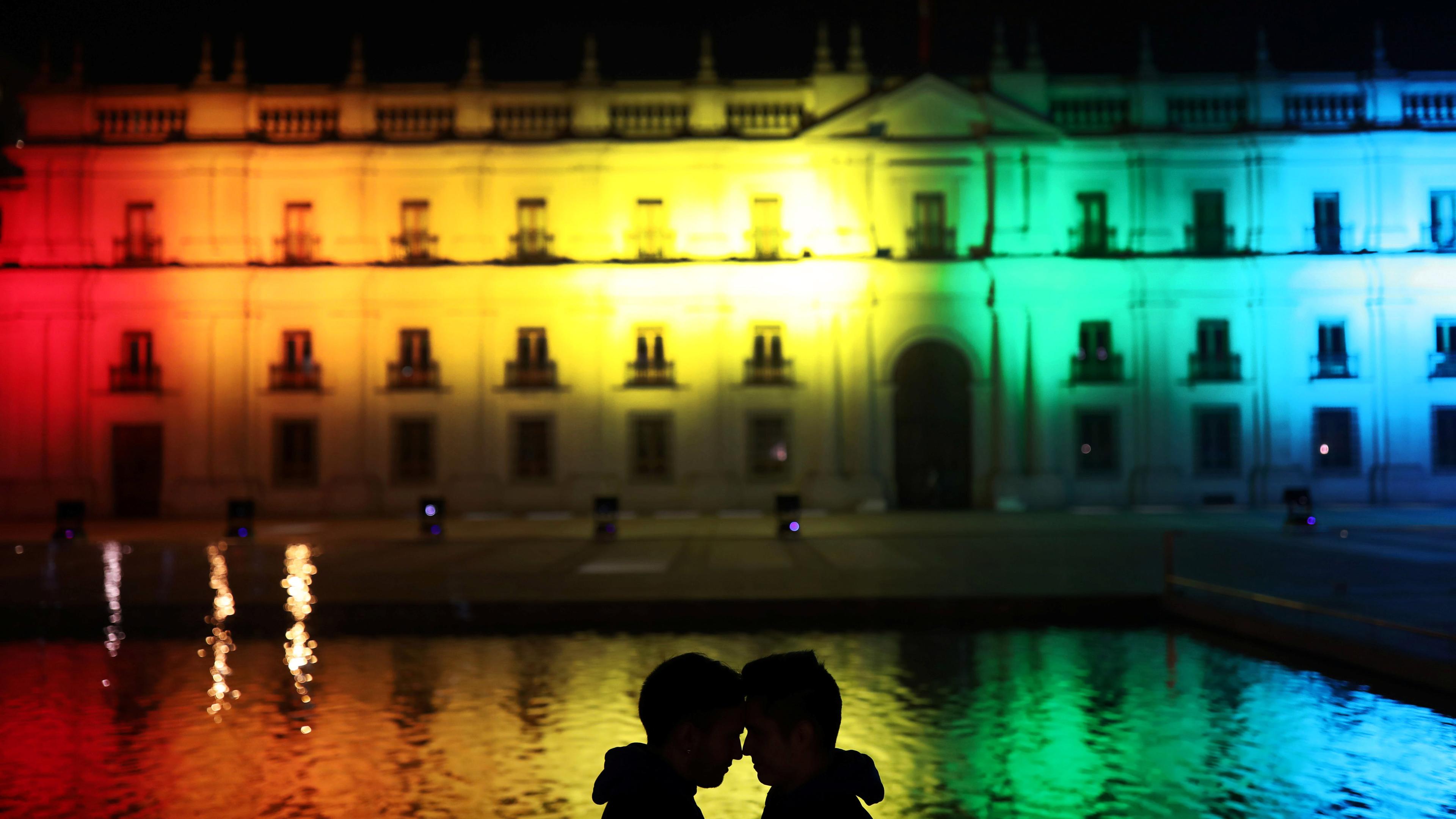 Paar vor einem Gebäude, das in bunten Farben bestrahlt wird