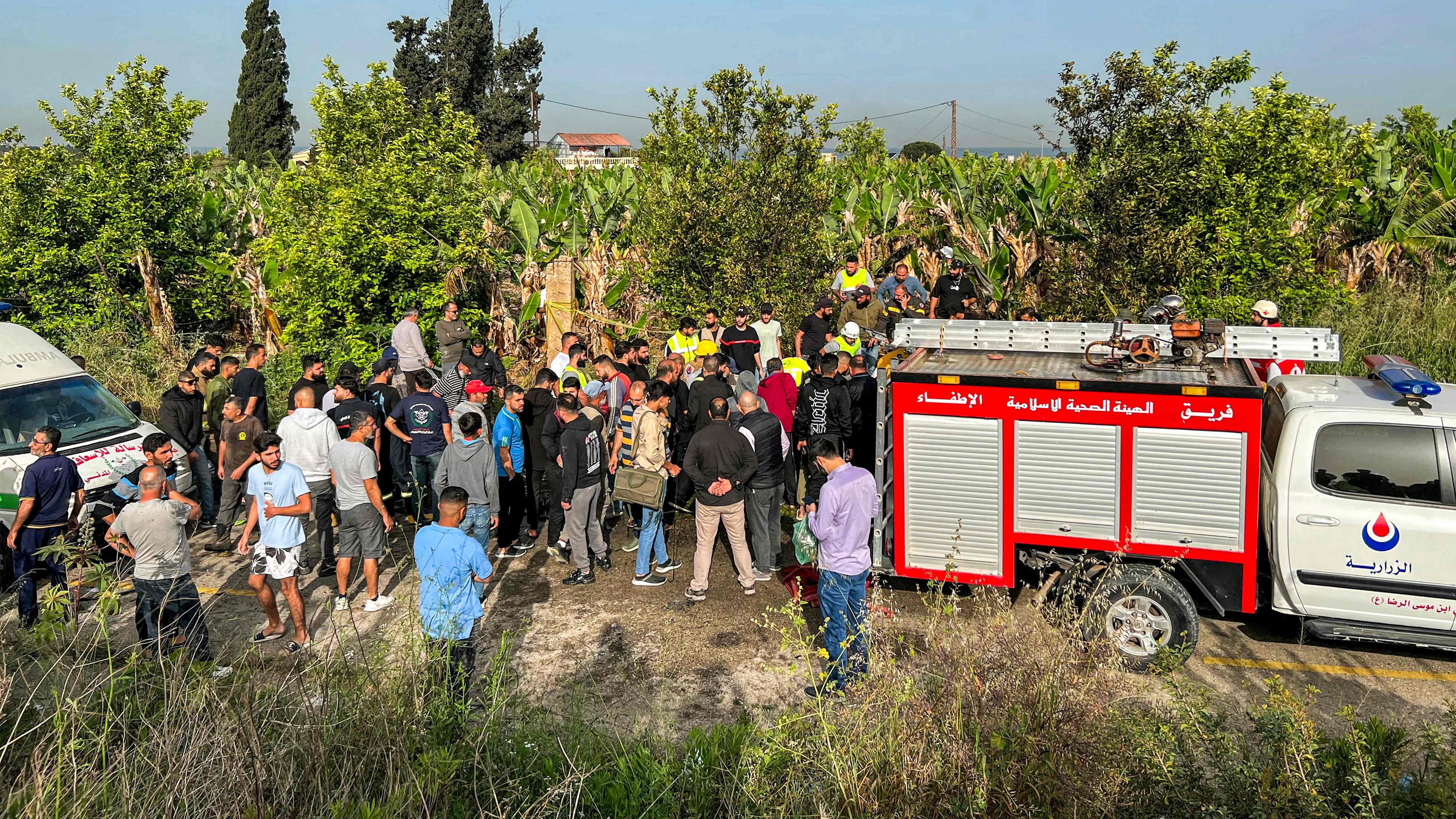 Menschen versammeln sich am 23. April 2024 am Ort eines israelischen Angriffs auf ein Fahrzeug in der Adloun-Ebene zwischen den südlichen libanesischen Städten Sidon und Tyrus.