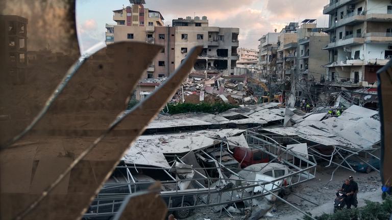  Ein zerstörtes Gebäude, das bei einem israelischen Luftangriff getroffen wurde, ist durch ein zerbrochenes Fenster des Jabal-Amel-Krankenhauses zu sehen. 