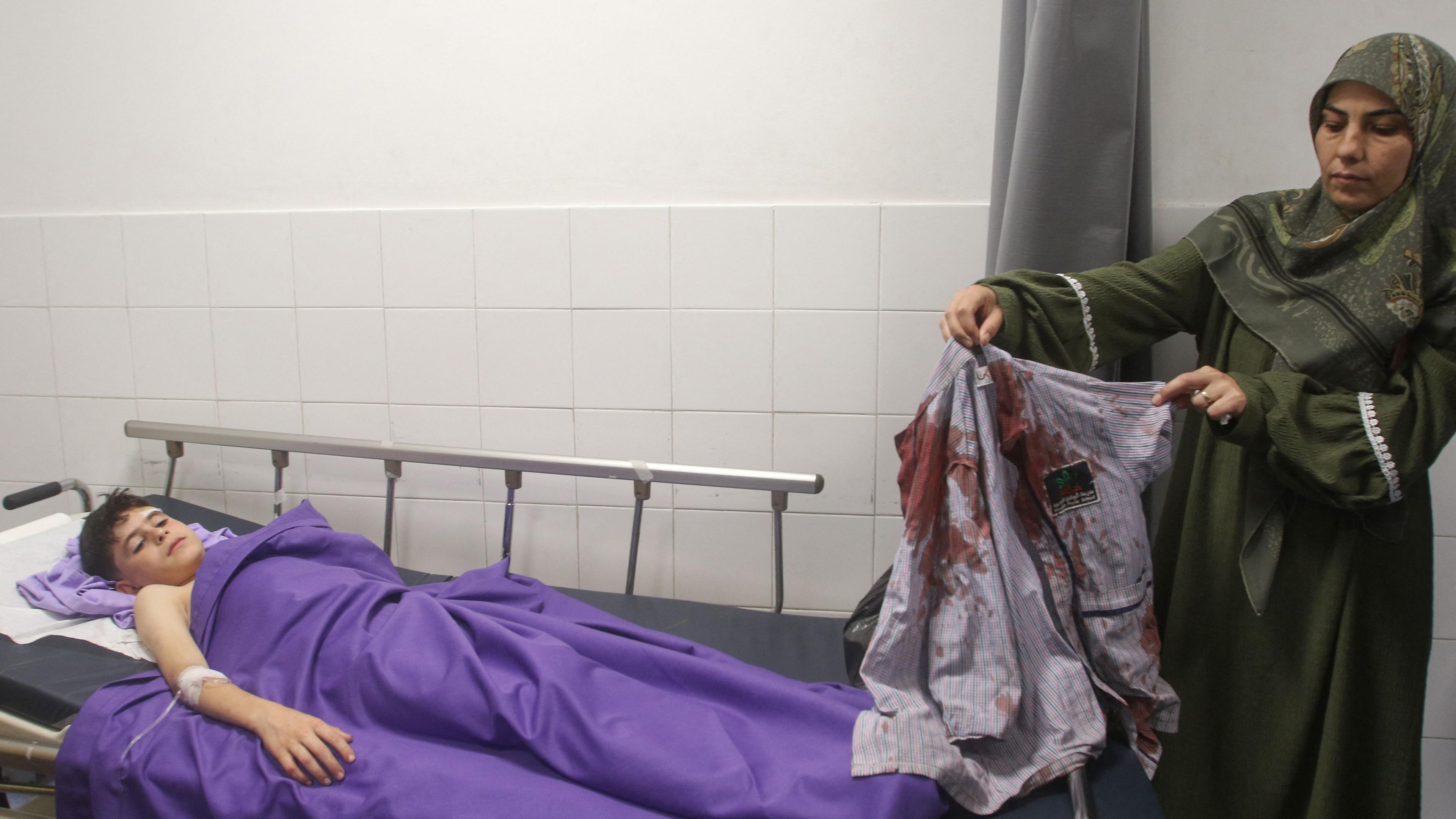 Die Tante des 11-jährigen libanesischen Schülers Mohammad Ali Nasser zeigt sein blutverschmiertes Hemd in einem Krankenhaus in Nabatieh