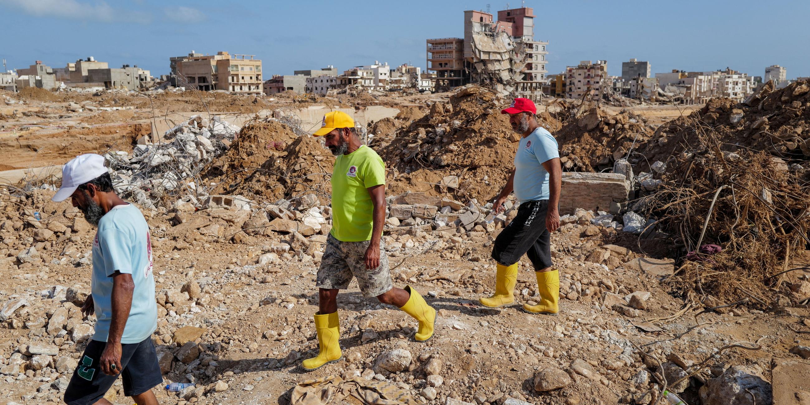 Local rescuers walk amid the rubble of destroyed houses and buildings in the aftermath of the deadly storm that hit Libya, in Derna, Libya September 21, 2023. REUTERS/Zohra Bensemra