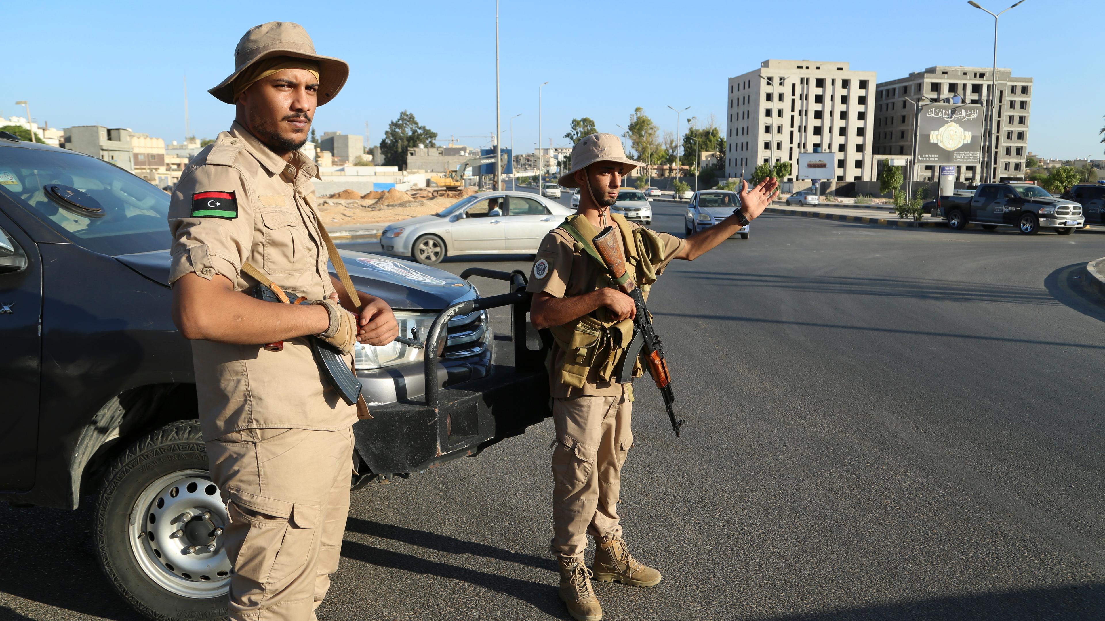 Mitglieder einer Sicherheitseinheit stehen Wache. In Libyen haben sich verfeindete Milizen in der Hauptstadt Tripolis die schwersten Kämpfe seit Monaten geliefert, nachdem eine Miliz den Kommandeur der sogenannten 444. Brigade festnahm. Der Flugverkehr am Flughafen der Hauptstadt und der Unterricht an der Universität wurden vorübergehend ausgesetzt.