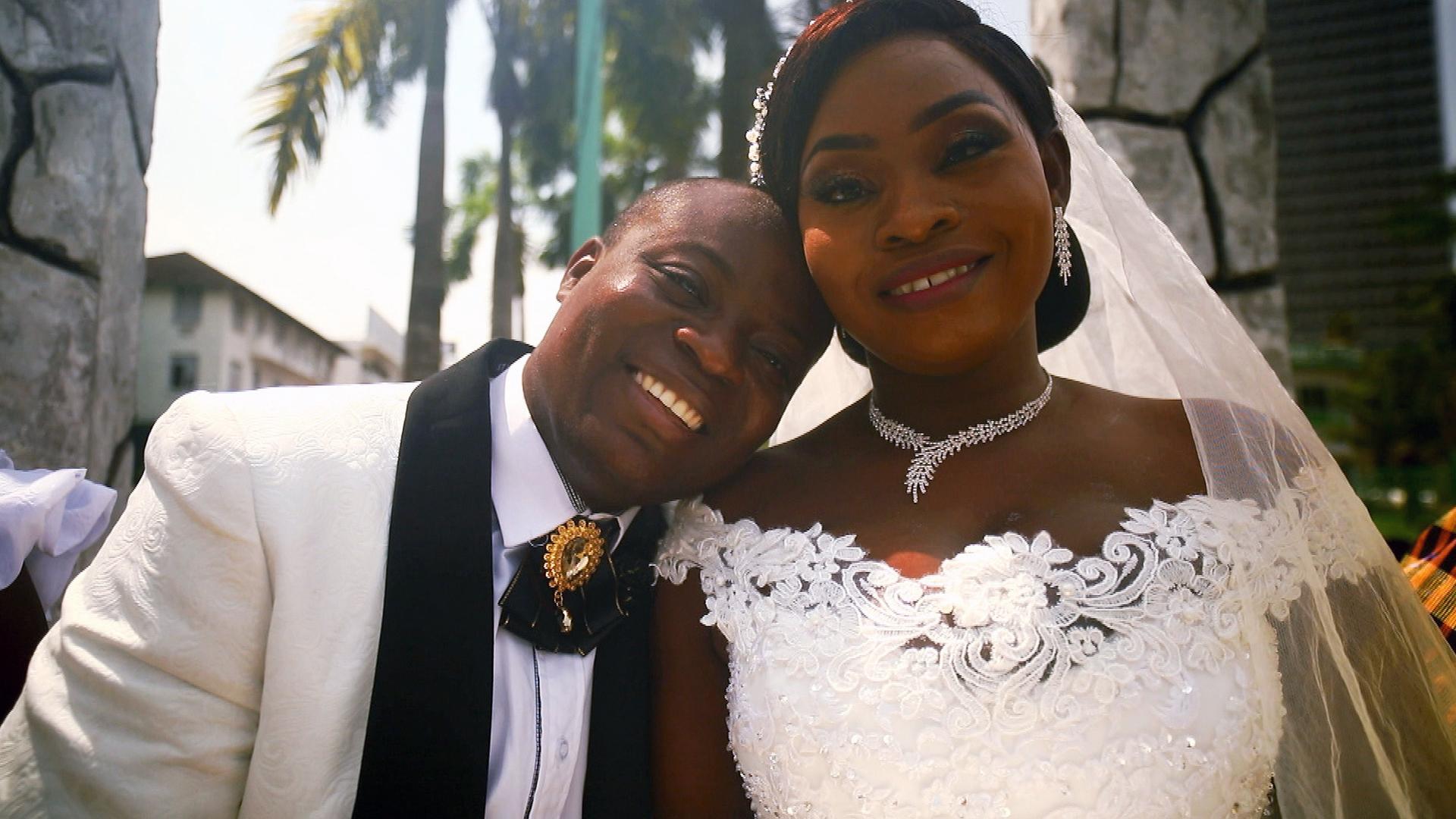 Bräutigam und Braut. Gebäude und Palmen im Hintergrund.