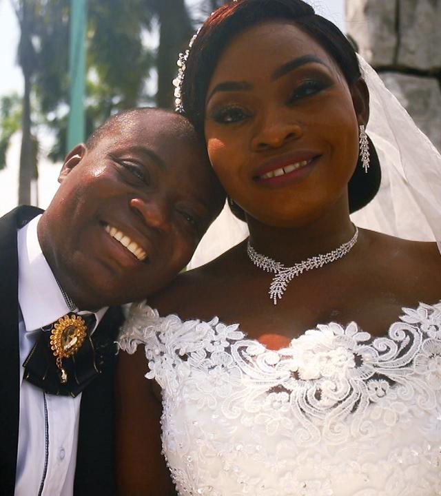 Bräutigam und Braut. Gebäude und Palmen im Hintergrund.