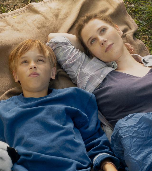 "Doktor Ballouz - Lieben und Lassen": Steffi Borgmann (Katrin Röver) liegt mit ihrem Sohn Finn (Otis Ray Whigham) auf einer Decke auf einer Wiese. Die beiden schauen verträumt in den Himmel.