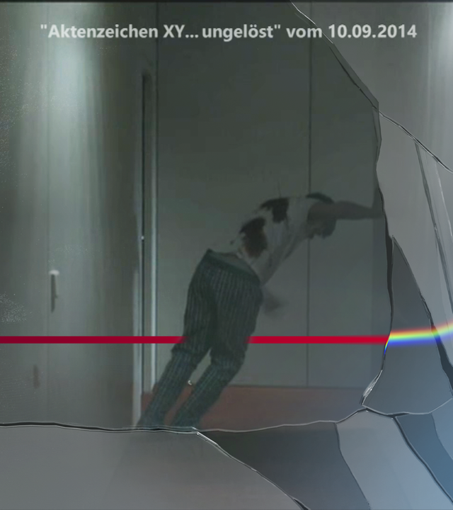 Nachgestellte Szene mit Schrift-Einblendung "Aktenzeichen XY...ungelöst vom 10.09.2014": Mann mit blutigen Stichverletzungen schleppt sich einen dunklen Hausflur entlang. Dabei stützt er sich an einer der Wände ab. Links daneben: Lichtschematische Darstellung eines Fingerabdrucks.