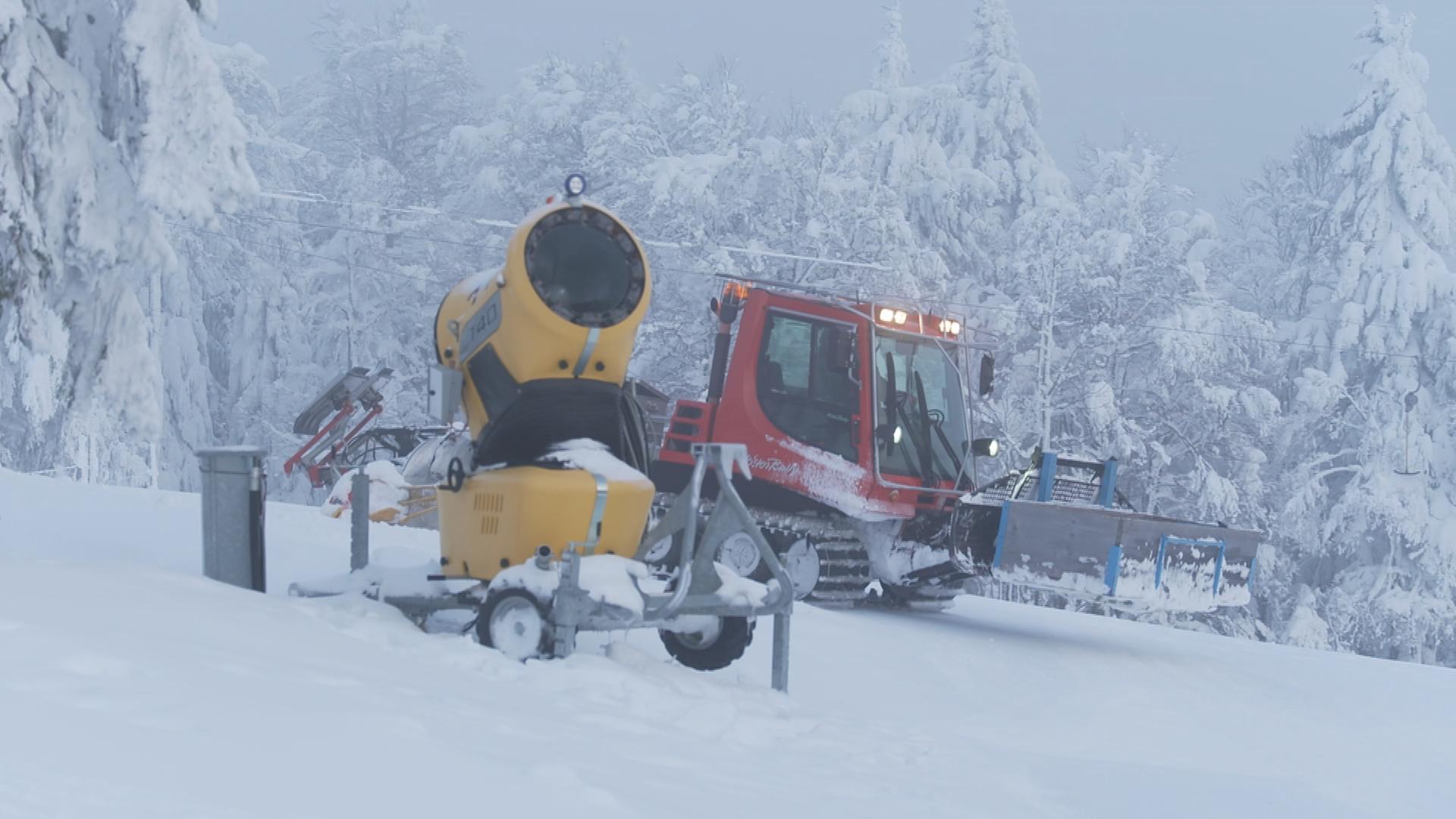 Eine Schneekanone und ein Schneeschieber im verschneiten Ski-Gebiet 