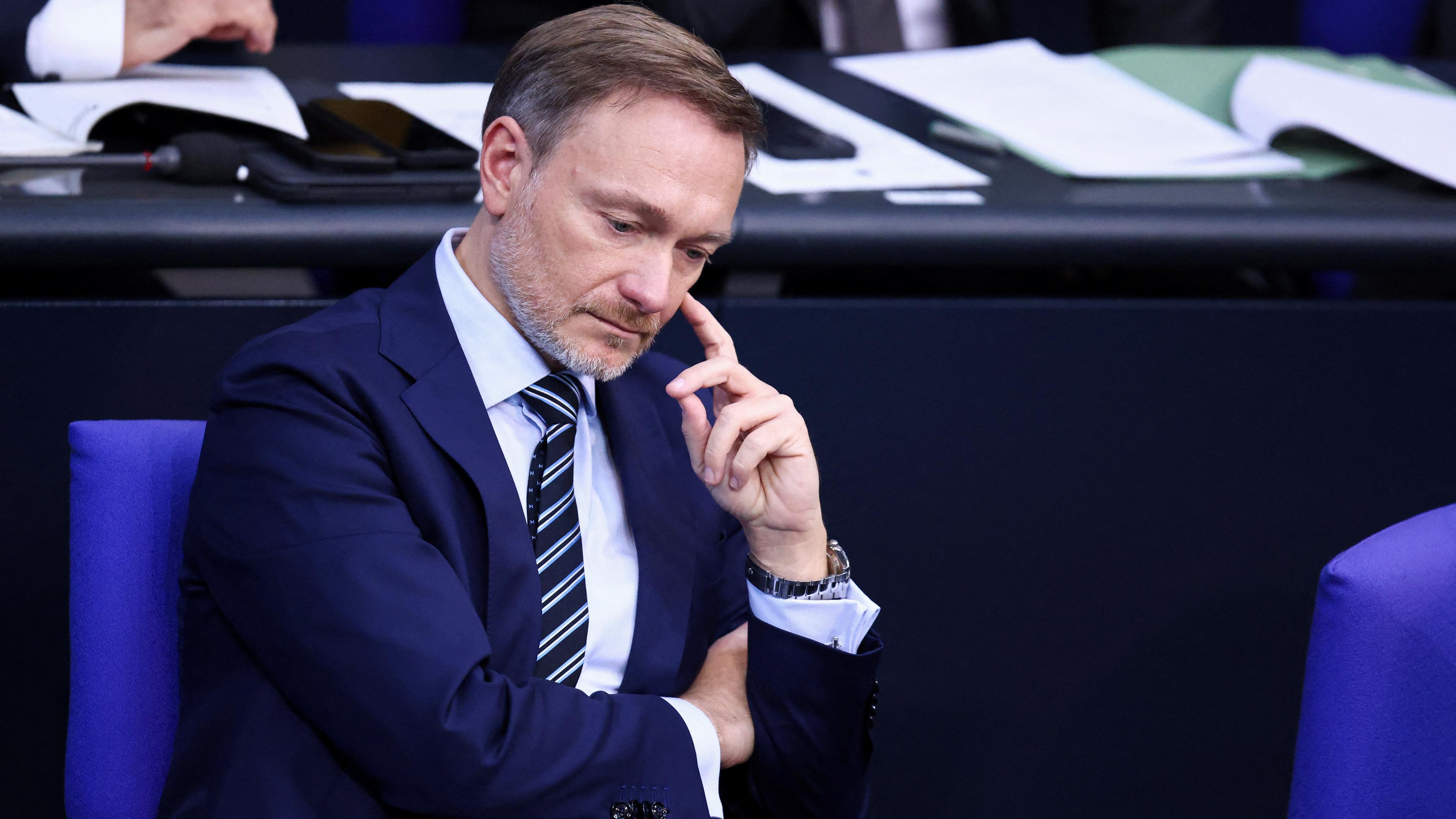 Christian Lindner sitzt nachdenklich und ernst auf seinem Platz im Bundestag 