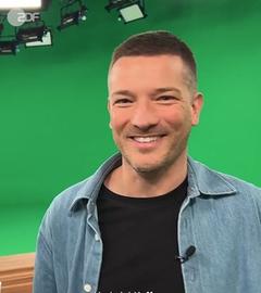 ZDF-Designer Felix Weitekampf lächelt vor einem Greenscreen in die Kamera