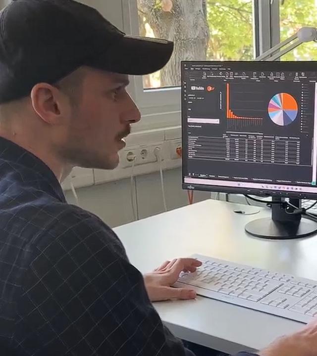 Gökay Boz, ZDF-Data Scientist nach dualem Studium im ZDF, an der Tastatur vor einem Recher voller Daten