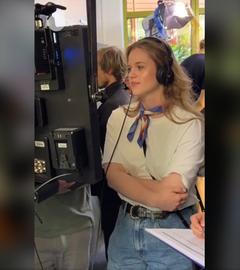 ZDF-Volontärin mit Kopfhörern schaut während der Dreharbeiten zum Volo-Kurzfilm "Der letzte Platz" auf einen Monitor