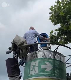 ZDF-Licht- und Veranstaltungstechniker Frank Bill aus der Froschperspektive auf einem Scheinwerfermast im Fernsehgarten beim Einrichten der Leuchte