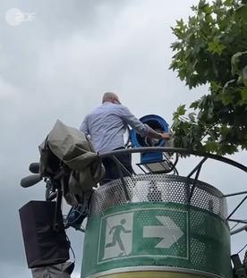ZDF-Licht- und Veranstaltungstechniker Frank Bill aus der Froschperspektive auf einem Scheinwerfermast im Fernsehgarten beim Einrichten der Leuchte