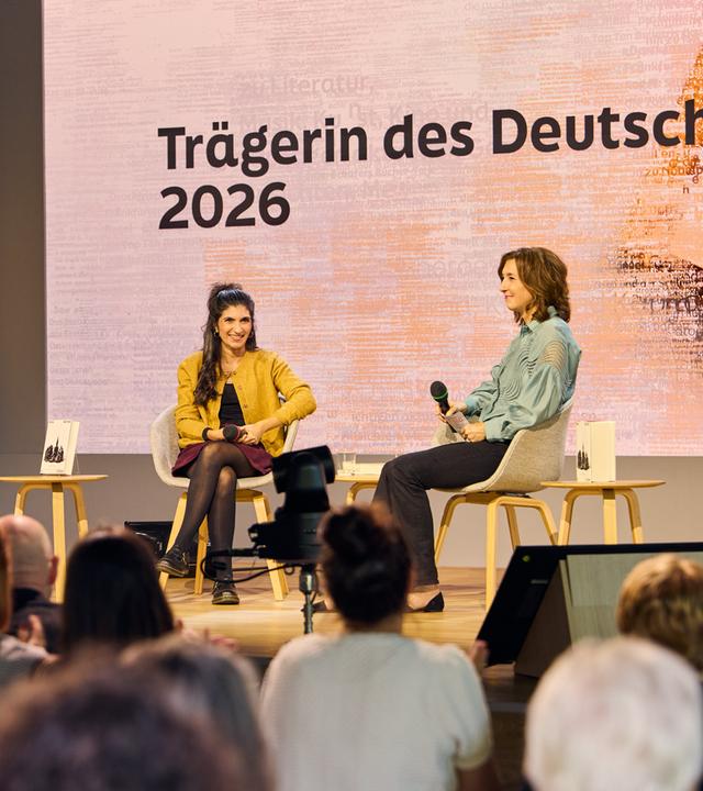 Zwei Frauen sitzen auf einer Bühne