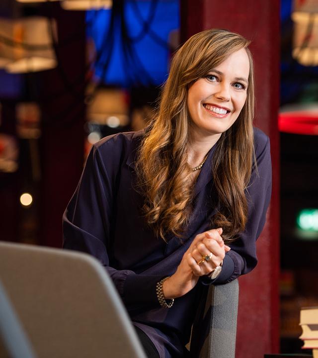 Die lächelnde Moderatorin Nicola Steiner seitlich über eine Armlehne gebeugt