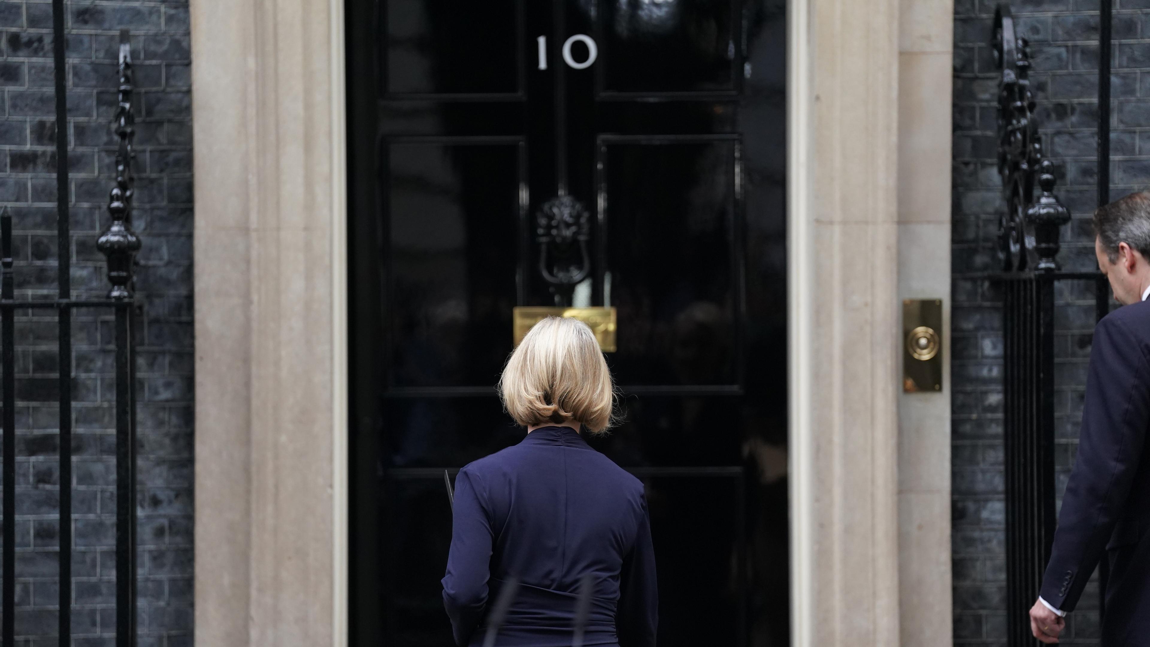 Liz Truss, Premierministerin von Großbritannien , gefolgt von ihrem Ehemann Hugh O'Leary , geht zurück in die Downing Street 10, nachdem sie eine Erklärung abgegeben hat.