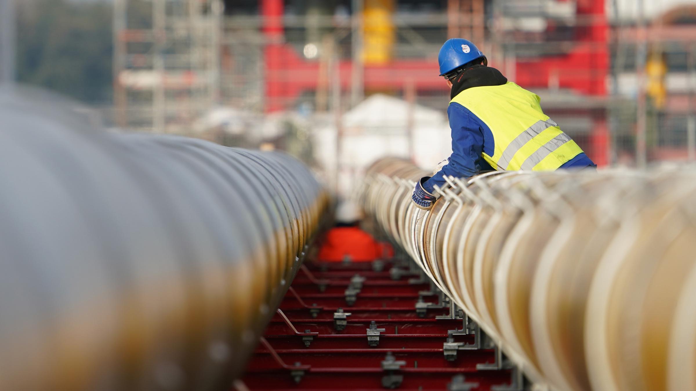 Workers assemble gas pipelines for the proposed LNG liquefied natural gas floating terminal.