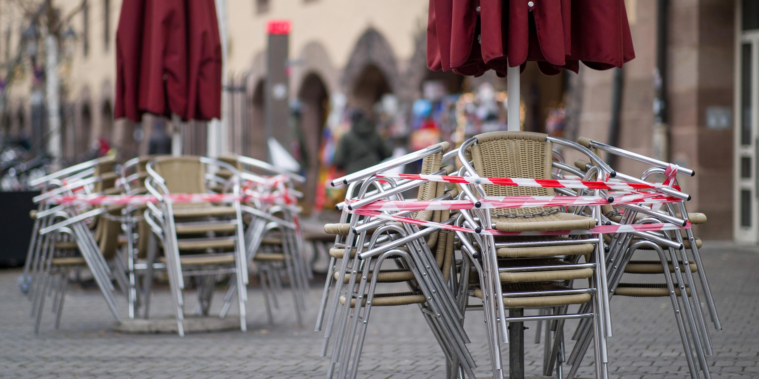 Stühle eines Cafes in der Nürnberger Innenstadt sind mit Absperrbändern gesichert (Archiv)