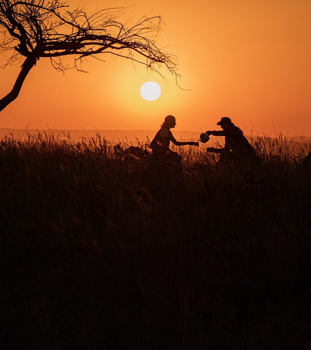 Fritz und Yasemin sitzen im Sonnenuntergang unter einem Baum