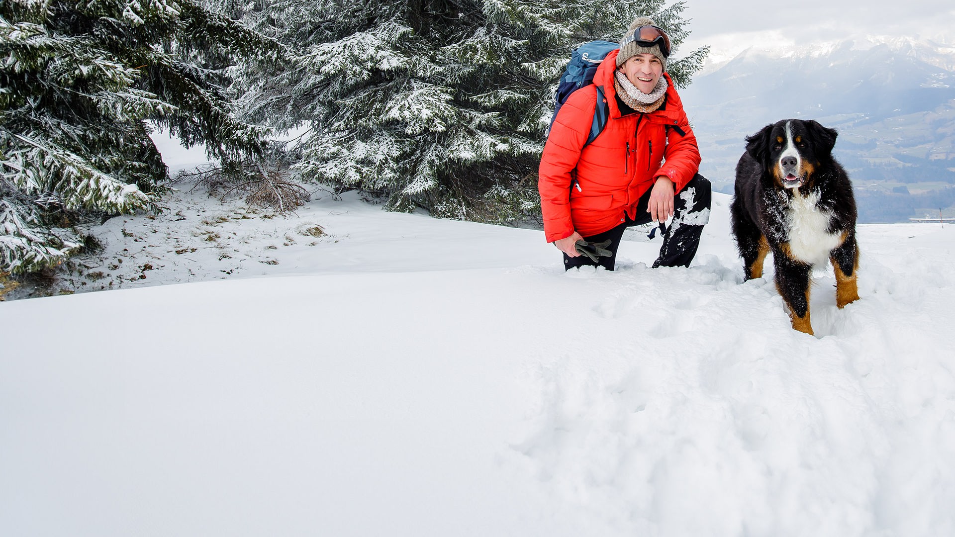 Fritz Fuchs und Keks stehen in den Bergen im Schnee