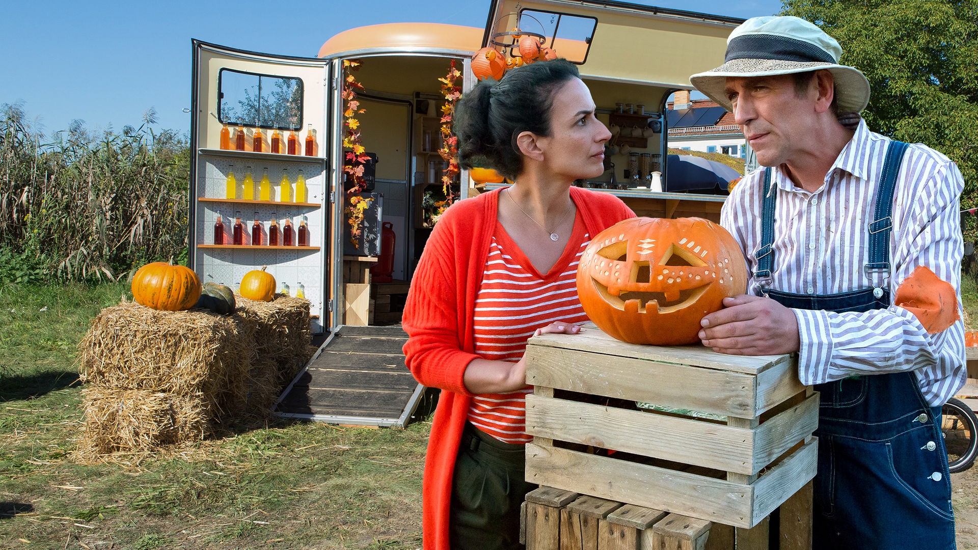 Yasemin und Fritz unterhalten sich - zwischen ihnen liegt ein Halloweenkürbis