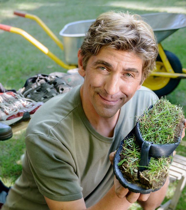 Fritz sitzt im Garten - im Hintergrund stehen viele verschiedene Schuhe