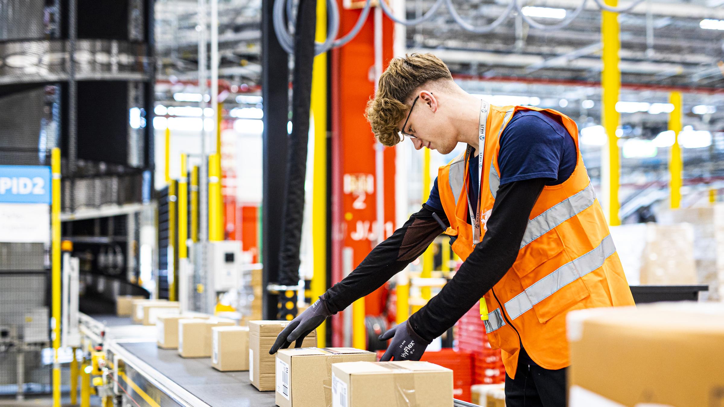  Ein Mitarbeiter legt im Logistikzentrum des Onlineversandhändlers Amazon in Helmstedt ein Paket auf ein Fließband.