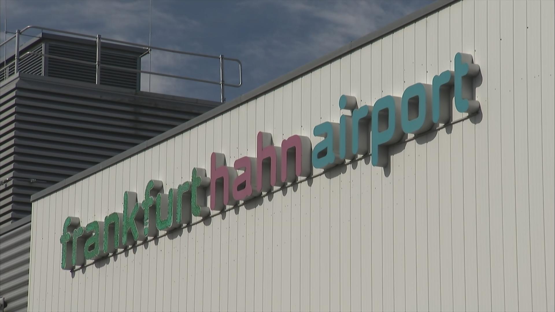 Auf dem Bild ist das Logo des Flughafen Hahns auf dem Gebäude zu sehen.