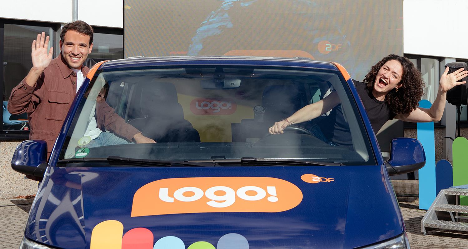 Logo!-Moderator Sherif Rizkallah und Moderatorin  Malral Bazargani winken aus den Seitenfenstern des Logo!-Tour-Busses