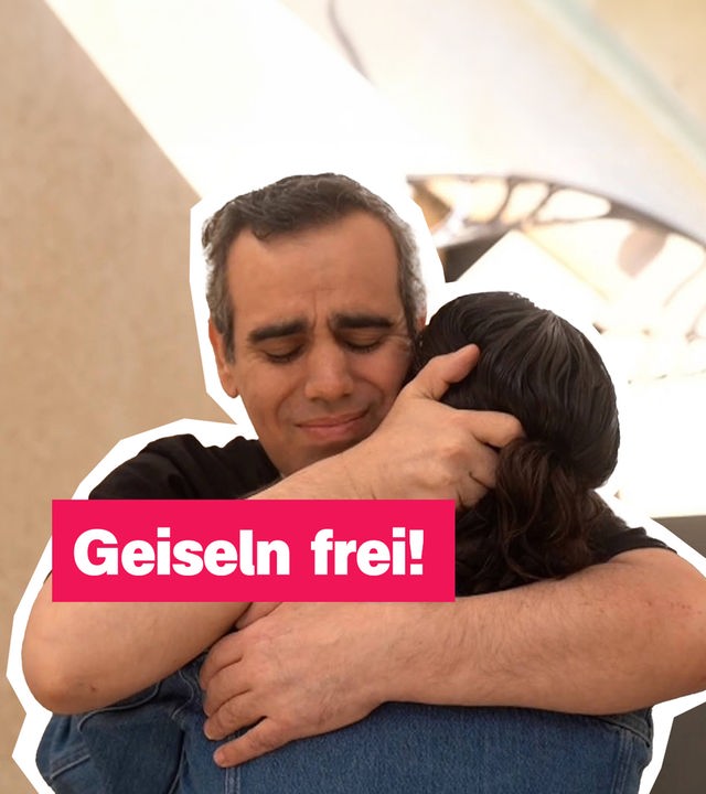 Ein Mann umarmt eine Frau, daneben steht: Geiseln frei!