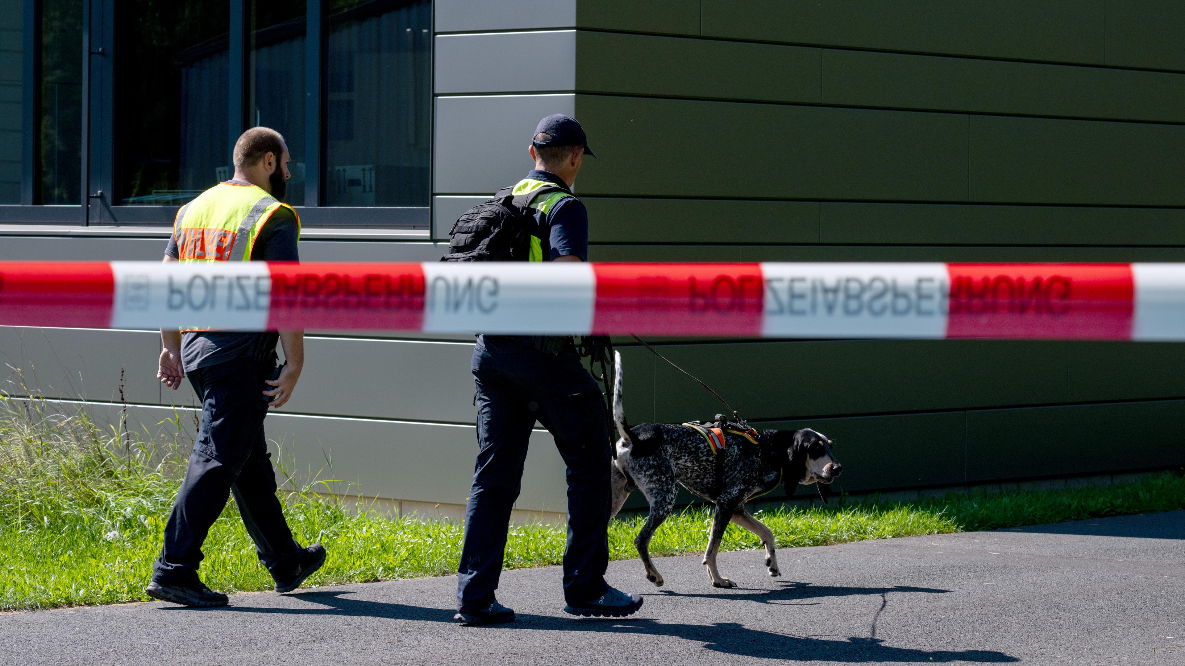 Bayern, Lohr Am Main: Mit einem Spürhund durchsuchen Polizeibeamte das Gebiet am Schulzentrum in Lohr am Main.
