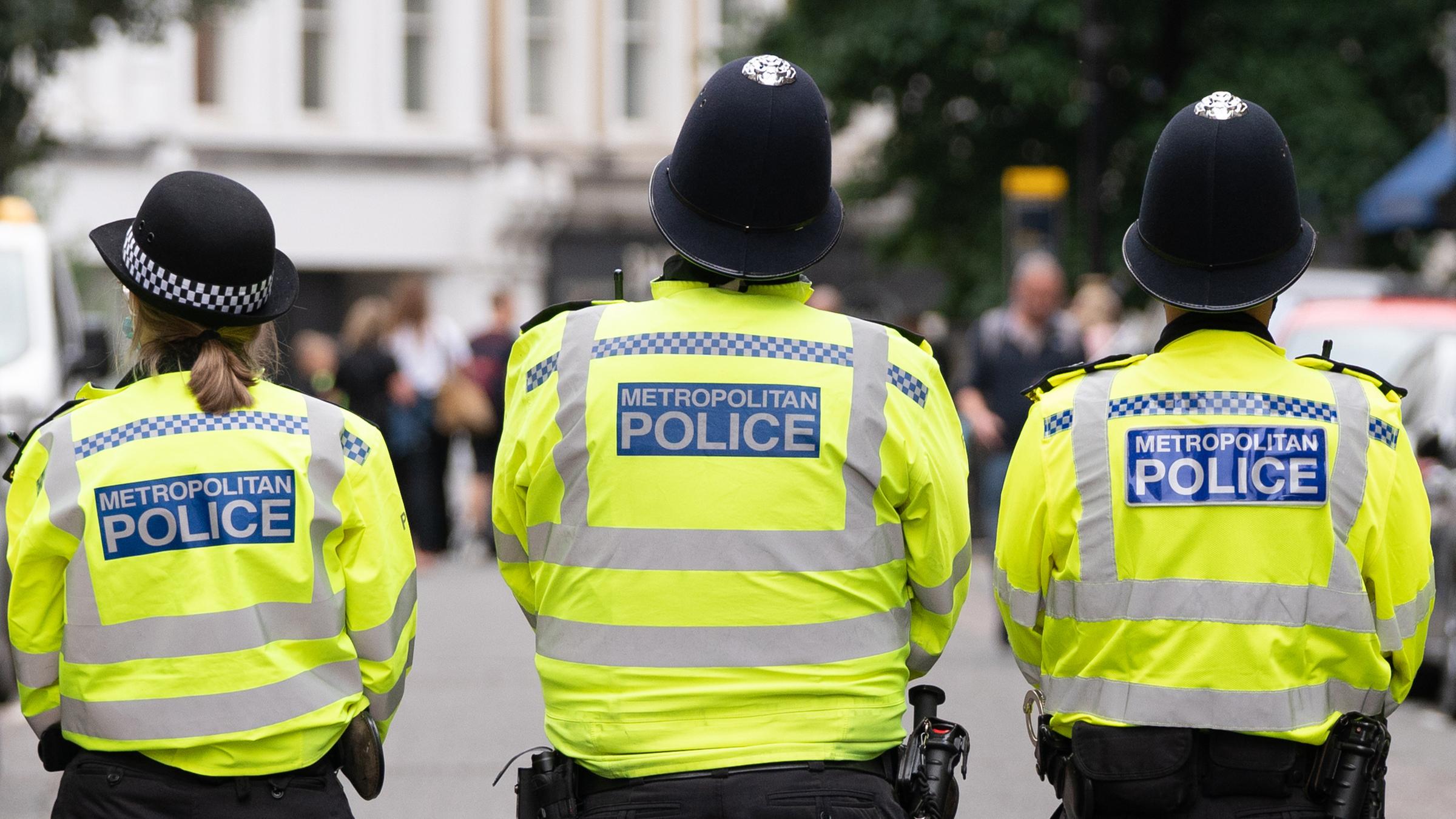 Großbritannien, London: Polizisten stehen während einer Demonstration von Mitgliedern der Extinction Rebellion auf einer Straße.