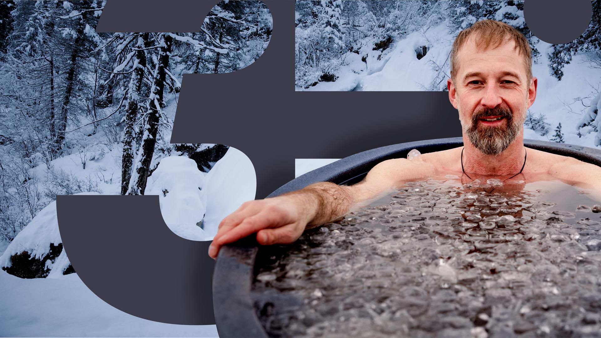 Ein Mann im Schneidersitz sitzt nur mit Badehose und Mütze bekleidet im Schnee in den Bergen.