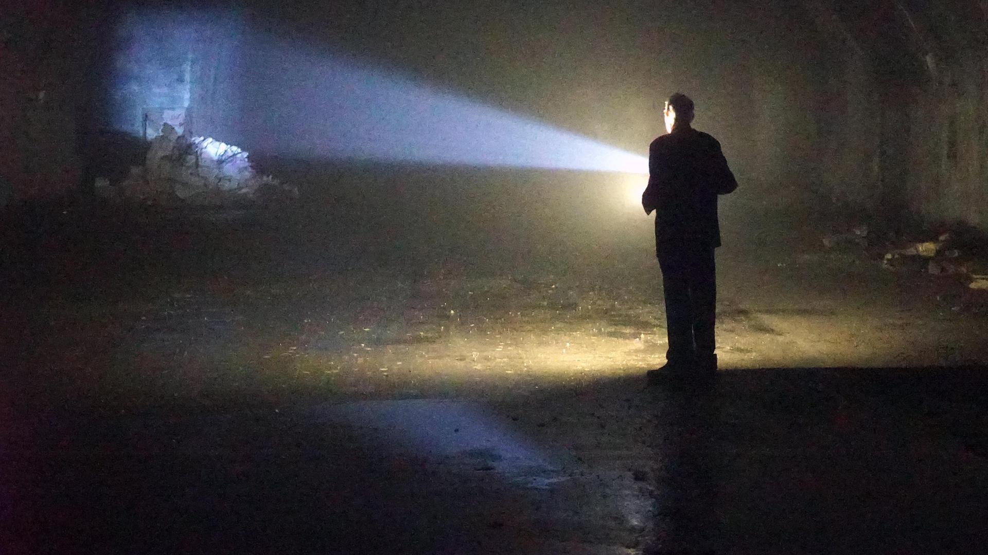 "Lost Places – Geheime Welten": Ein Mann steht in einem Tunnel und hat eine Taschenlampe in der Hand.