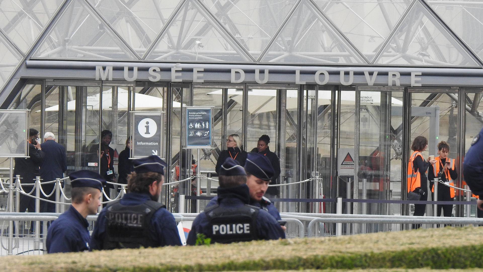 Man sieht Polizeibamte, die vor dem Louvre stehen und den Zugang sperren