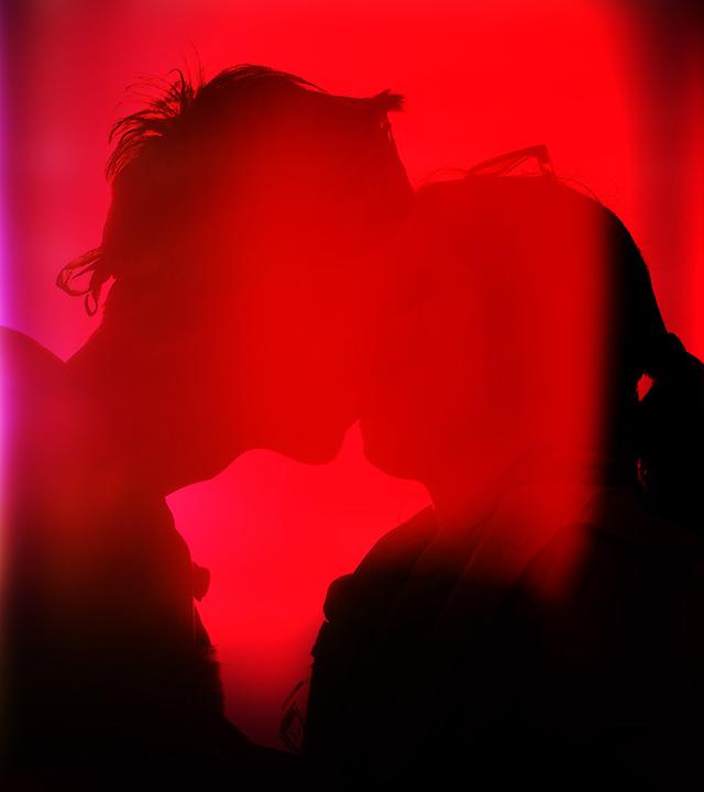 Schatten eines küssenden Paares vor rotem Licht