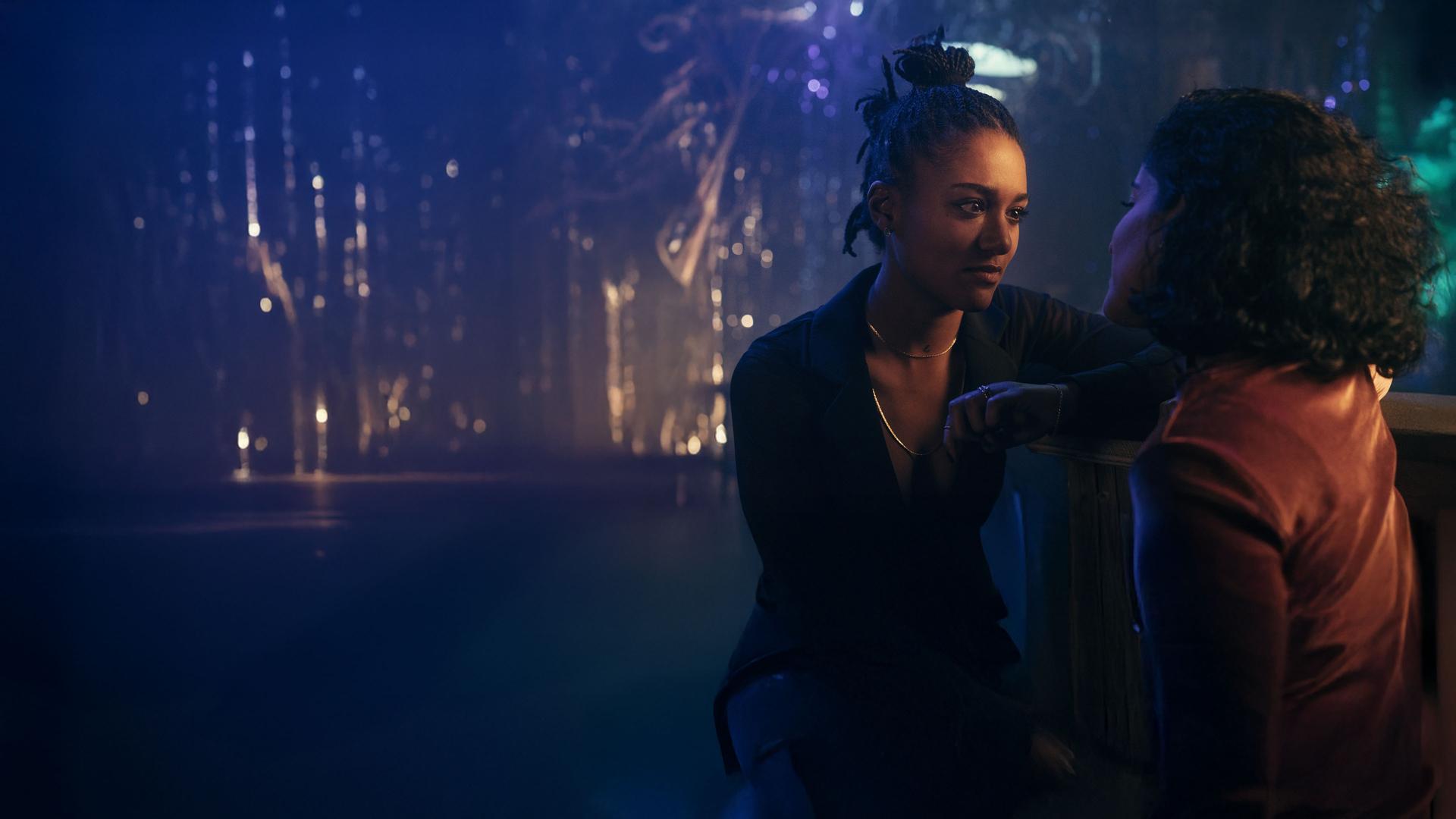 "Loving Her - Loving Anouk": Anouk (Larissa Sirah Herden) und Hanna (Banafshe Hourmadzi) sitzen eng nebeneinander in einem Nachtklub und sehen sich verliebt an.